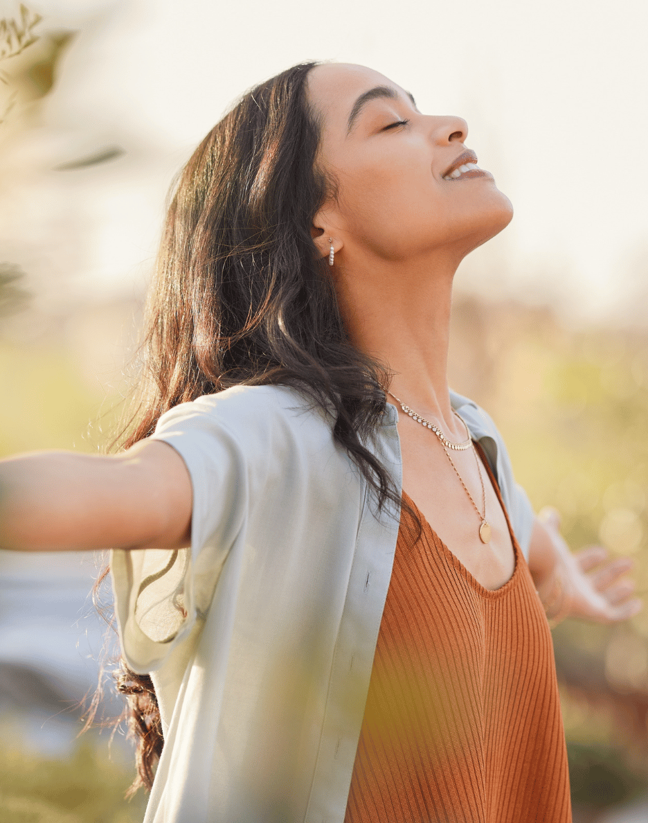 Woman releasing emotional weight and embracing freedom in sunlight — representing C.L.E.A.R. DNA's cellular-level healing and the release of stored emotional frequencies